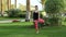 Sports girl doing basic exercises from yoga standing barefoot on the lawn. Brunette in stylish sports clothes does