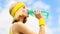 Sports girl drinks water from a bottle on a sky background. Healthy lifestyle concept. Drinking during sport. Young