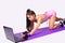 Sports girl in sexy shorts changing position in fitness exercises knee touching fitness mat watching them online.