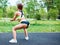 Sports girl in sportswear squatting in the summer park.