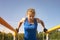 A sports girl is training in the park on the horizontal bars