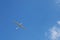 Sports glider in clear blue sky. A blue sky background with a small airplane to depict freedom, flight, endless possibilities