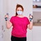 Sports in the home kitchen, training during the coronavirus epidemic. Woman doing fitness in the kitchen with dumbbells in hand,