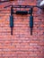 A sports horizontal bar mounted on a red brick wall of a house. Outdoor gymnastics workout equipment