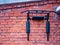 A sports horizontal bar mounted on a red brick wall of a house. Outdoor gymnastics workout equipment