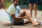 Sports injury. Young tennis player touching his knee while sitting on the tennis court