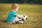 Sports kid. Boy playing football. Baby with ball on sports field