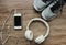 Sports kit for running: large white headphones, mobile phone, running shoes on the wooden background