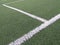 Sports lines painted on a green grass pitch. White lines painted on artificial grass on a soccer field View of artificial grass on