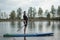 Sports man in a medical mask rowing a paddle standing on a Board, prevention of covid