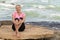 Sports mature woman sitting at the beach and smiling