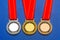 sports medal with red ribbon, gold, silver, bronze on a blue background