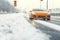 Sports orange car on a snowy city road, winter landscape in snowfall