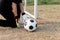 Sports and recreation concept a male teenage goalkeeper wearing black outfit and a pair of colorful gloves holding a soccer