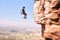 Sports, rock climbing and jump with woman on mountain for fitness, adventure and challenge. Fearless, workout and hiking