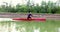 Sports rowing on the kayak. The man floats down the river along the wood