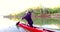 Sports rowing on the kayak. The man floats down the river along the wood