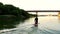 Sports rowing on the kayak. The man floats down the river along the wood.