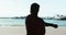 Sports, silhouette and a man stretching on the beach during fitness, exercise or training outdoor from behind. Health