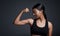 Sports, smile and woman flexing bicep in studio isolated on black background. Strong, happy and Indian female athlete