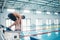 Sports, swimming and man on podium by pool for training, exercise and workout for competition at gym. Fitness, wellness