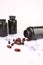 Sports tablets supplements, black medicine jars with scattered transparent capsules, vitamins, fish oil. White background