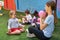 Sports teacher plays ball with children outside the daycare center