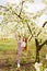 sports teenage girl with long hair walks in a clearing between flowering trees