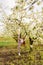 sports teenage girl with long hair walks in a clearing between flowering trees