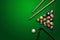 Sports theme with billiards, a full set of billiard balls, cue, on a green background. top view, flat lay, copy space, snooker.