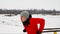 A sports trained man performs push-ups on parallel bars in the winter in the open air. Close-up