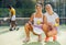 Sports women with padel rackets posing on tennis court