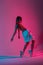 Sports young woman dancer in a youth fashion toh in hoodie in stylish sneakers dancing hip-hop in the studio with bright pink neon