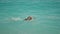 sportsman athletic man swims in turquoise water of mediterranean sea in Oludeniz Beach in Aegean Sea. Summer tourist