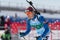 Sportsman biathlete Cheon Yunpil South Korea in action skiing on ski track distance biathlon arena. Junior biathlon