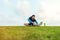 Sportsman with a bottle of water sitting and doing warming stretching exercise in the park