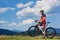 Sportsman cyclist standing with cross country bike, enjoying beautiful view of distant mountains