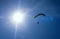 The sportsman flying on a paraglider. Paragliding Silhouette on blue sky. Paragliding take off. Travel destination