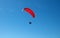 The sportsman flying on a paraglider. Paragliding Silhouette on blue sky. Paragliding take off. Travel destination