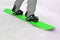 Sportsman with green snowboard closeup on white snow, winter seasonal sport entertainment,