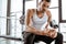 Sportsman holding sports bottle with protein milkshake and looking at camera in gym