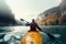 A sportsman on a kayak floats on a mountain river, rear view. Generative ai