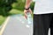 Sportsman keeping water bottle standing on racetrack.