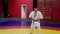 Sportsman in kimono explains karate moves in gym at training