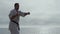 Sportsman learning martial arts on seashore. Bearded man practicing fight skills