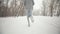 Sportsman legs runs in sportswear and sneakers in winter park, back view, closeup. Man jogging winter park during