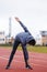 Sportsman makes exercises on a running track