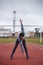 Sportsman makes exercises on a running track