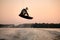 sportsman making trick in jump time with wakeboard on sky background.