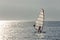 Sportsman practicing windsurfing at sunset